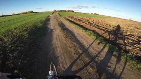 View shot from the driven bike with bicyclist's shadow on rural bad road, 4K Stock-Footage 59072160