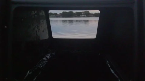 View shot through a Recycle Trash can by the water. With houses Stock Footage 259985367