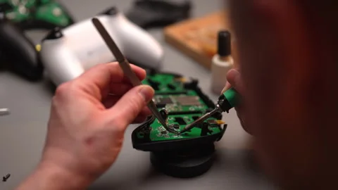 View from shoulder of electronic technician soldering components on circuit Stock Footage 304863357