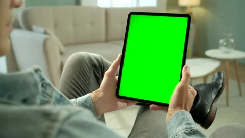 View From the Shoulder of Man Holding and Using Hand Gestures on Green Mock-up Stock Footage 133280666