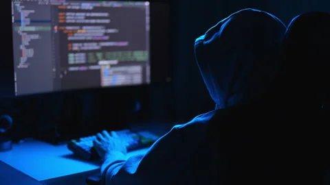 View from shoulder of unrecognizable man hacker in sweatshirt typing on desktop Video stock 277466933