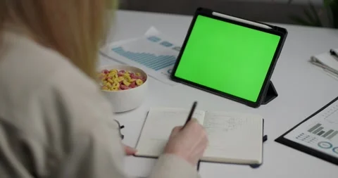 View from the shoulder of woman using tablet with green mock-up screen. Stock Footage 243524959