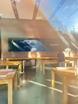 View from the showcase at Empty tables of Apple Store with no customers inside 스톡 사진