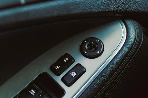 View shows controls on the door panel of a car, including buttons and knobs f Stockfoto's