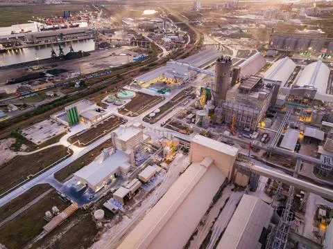 The view shows an industrial facility with multiple buildings and structures. Stock Photos