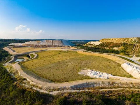 The view shows a large mining site with hills in the background. There are ar Stock Photos