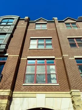 The view shows multiple windows on a brick building. The sky is clear with no Stock Photos