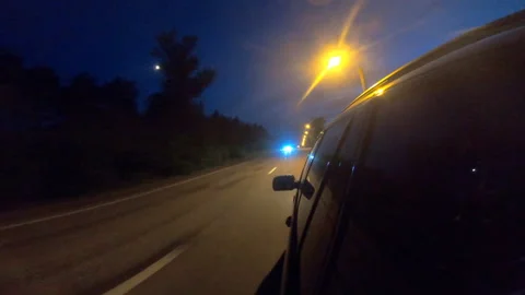 View from side of black suv racing through countryside highway at night Stock Footage 157975567