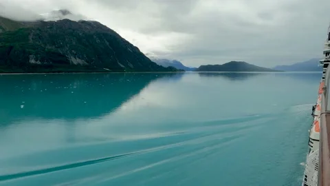 View side of cruise ship making gentle ripples in smooth water of Glacier Bay Stock Footage 208940274