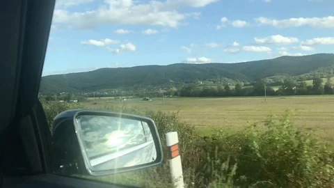 View in side mirror from vehicle on highway. Driving a car along field Stock Footage 118249735