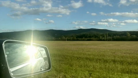 View in side mirror from vehicle on highway. Driving a car along field Stock Footage 118249736