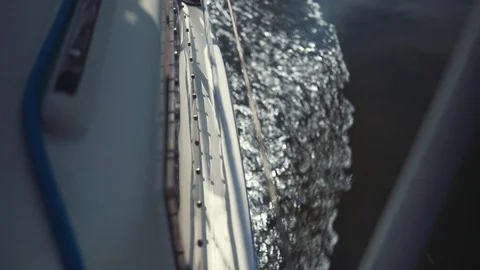 View from side of moving sailing boat. Yacht cuts waves of water surface. Sea Stock-Footage 125366691