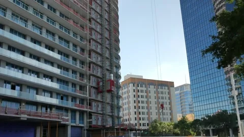 View up side of multi-story tall building and cranes under construction. Tempora Stock Footage 276635799
