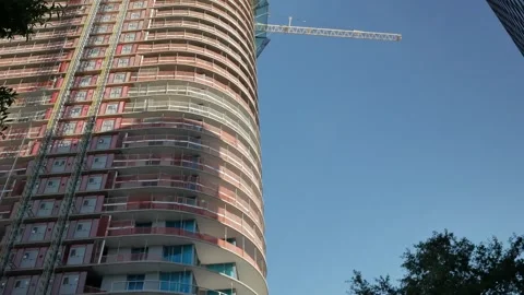 View up side of multi-story tall building and cranes under construction. Crane c Stock Footage 276635800