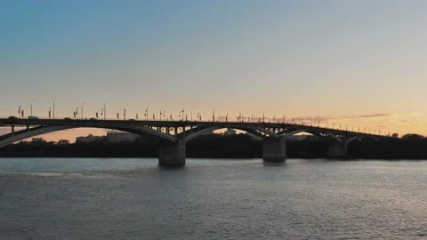 View from the side on the road bridge across the river at sunset. Beautiful Stock Footage 185275228