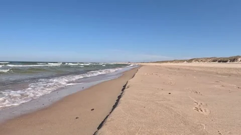 View from the side of the sea waves crashing on the wide sandy beach shore Stock Footage 239088322