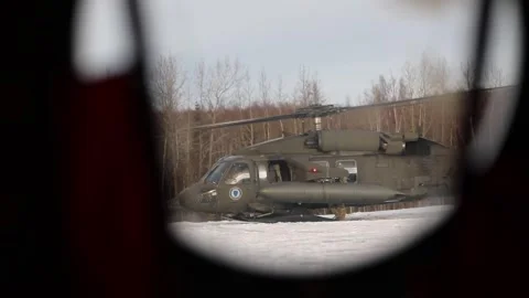 View from side window of CH-47 Chinook, showing UH-60 Black Hawk parked on snow Stock Footage 295350168