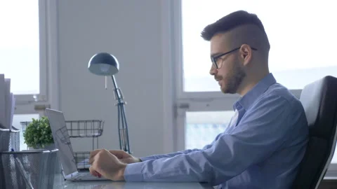 View from the Side A Young Thoughtful Man Working On A Startup Project Stock Footage 146319036