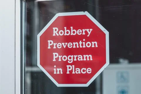 View of sign on the window Robbery Prevention Program in Place in Courtenay Stock Photos