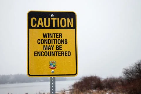 View of sign Winter Condition may be Encountered with snow in the background Stock Photos