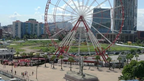 View of silhouettes of rotating ferris wheel, alphabet tower Vidéo 237174978