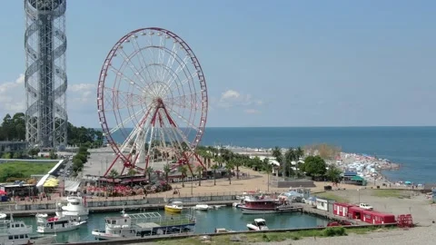 View of silhouettes of rotating ferris wheel, alphabet tower Stock Footage 237175030