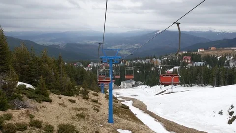View from a ski lift that is going down the mountain over the ski pistes. Stock Footage 77229014