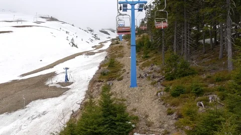 View from a ski lift that is going up the mountain over the ski pistes. Stock Footage 77228616