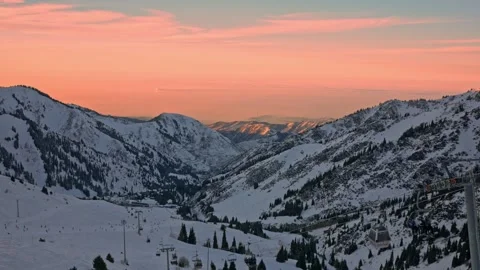 A view of a ski resort, a beautiful sunset, people skiing and snowboarding Stock-Footage 241924391