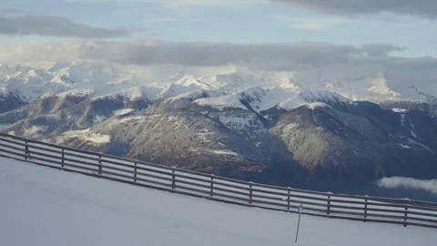 View from the Ski Slope Over Snowy Mountain Ridges and Cloud-Covered Peaks in Stock Footage 307389341