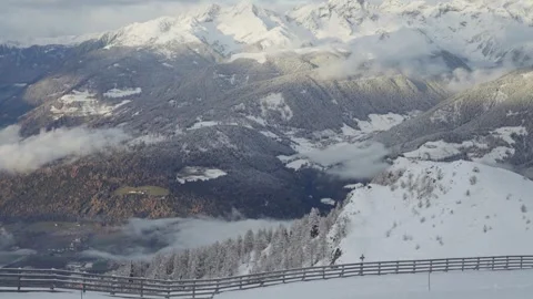 View from the Ski Slope Over Snowy Mountain Ridges and Cloud-Covered Peaks in Stock Footage 307907345