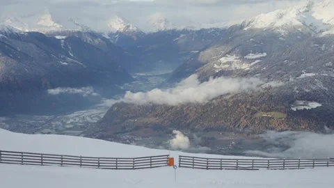 View from the Ski Slope Over Snowy Mountain Ridges and Cloud-Covered Peaks in Stock Footage 307907585