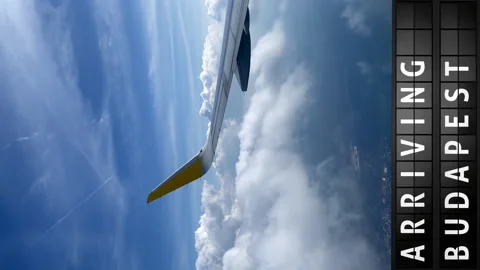 View of the sky from an airplane and a display board with arriving in Budapest Stock Footage 197330434