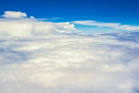 View of the sky clouds above the clouds from airplane window Stock Photos