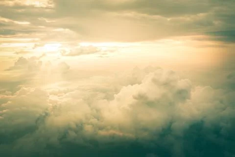 View of the sky clouds above the clouds from airplane window with sun light Stock Photos