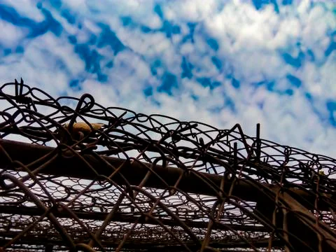 View of the sky with clouds due to barbed wire. The concept of educating resp Stock Photos