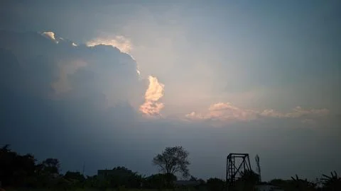 A view of the sky with clouds illuminated by sunlight from behind the clouds. Stock Photos