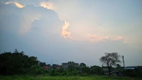 A view of the sky with clouds illuminated by sunlight from behind the clouds. Stock Photos