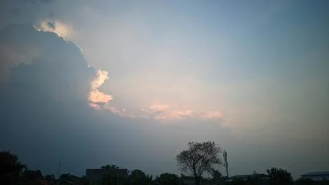 A view of the sky with clouds illuminated by sunlight from behind the clouds. Stock Photos