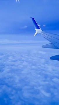 View of the Sky with Clouds Under an Airplane Wing Stock Photos