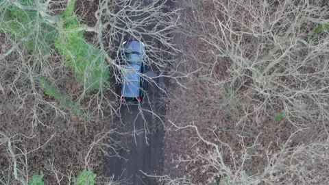 View from the sky: a station wagon makes its way through a muddy, puddle-st.. Stock Footage 260732923