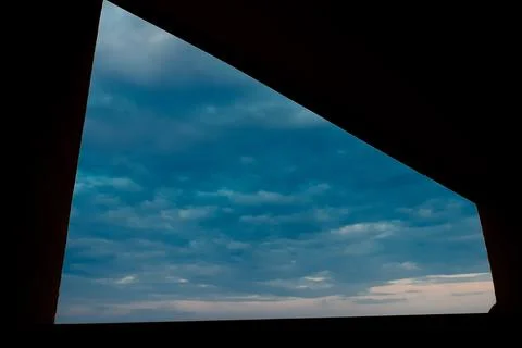 View of the sky through a triangular opening in a building. clouds are visibl 스톡 사진
