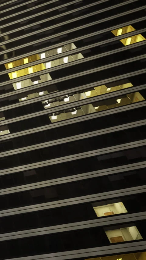 View of skyscraper windows with patterns in urban setting at night Stock Footage 342451473