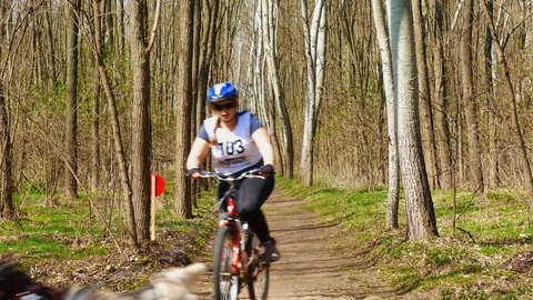 View on the sleddogs racing with their trainer on a bike during the event Stock Footage 106105257