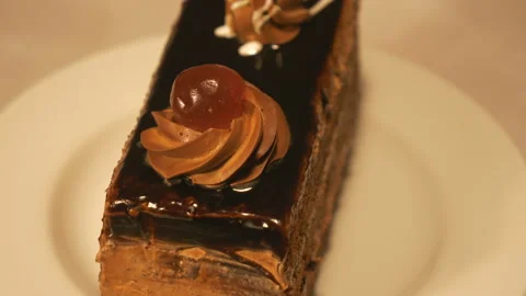 A view of a slice of brown cake with a cherry on top. Stock Footage 125289380