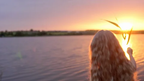 View in slow motion from back of little blond girl 7-8, walking at river or lake Stock Footage 91223458