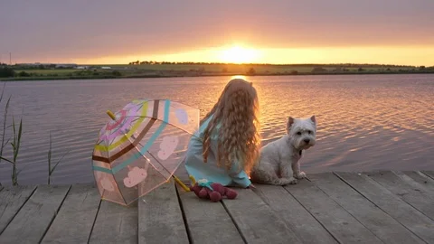 View in slow motion of cute blond girl 7-8 wearing straw hat, sitting on wooden Stock Footage 91223215