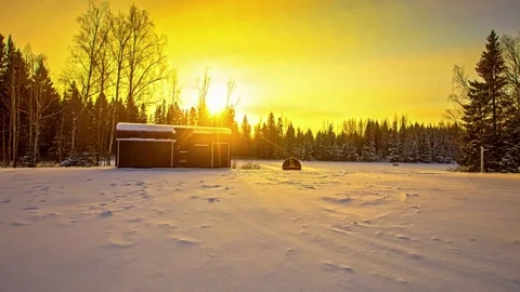 View of a small cabin in a snowy forest at sunset, Latvia. Vidéo 340639187