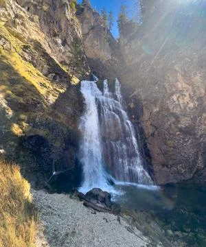 View of a small cascading waterfall in the Austrian Alps in sunlight Foto stock