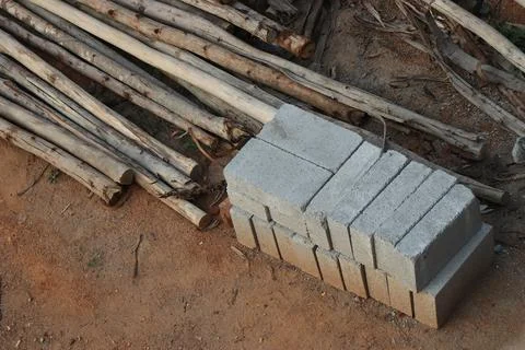 View from a small construction site where the pile of bricks and wooden poles Stock Photos